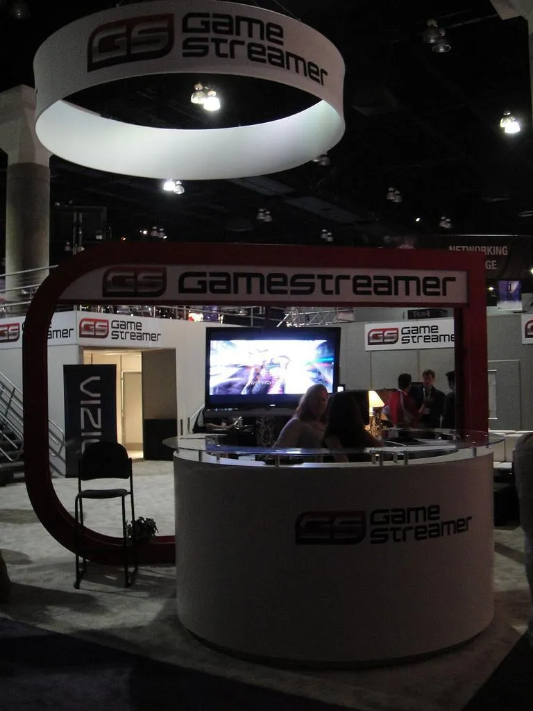 The front desk of the GameStreamer booth under a large illuminated ring