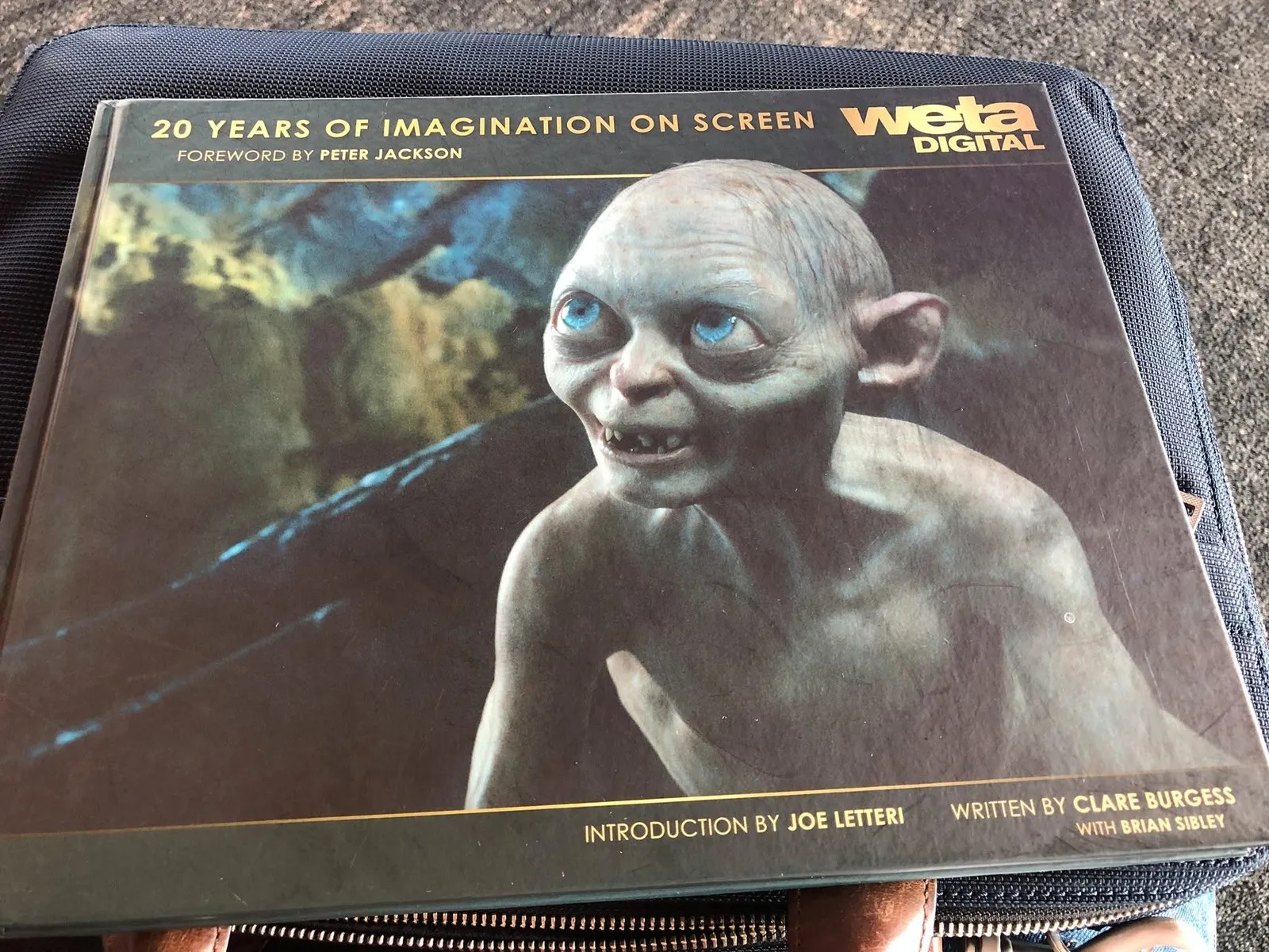 A hardcover book, Weta Digital: 20 Years of Imagination on Screen, with Gollum on the cover